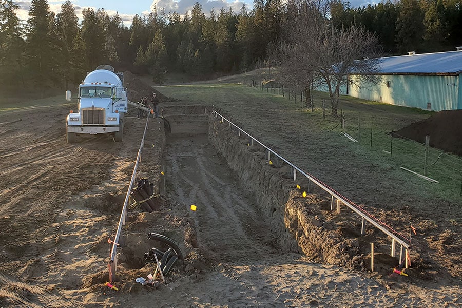 2023-40-greenhouse-in-the-snow-canada Concrete being poured into insulated trench for geothermal piping system during greenhouse build in British Columbia
