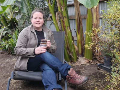 Chelsea enjoying a cup of coffee in the greenhouse